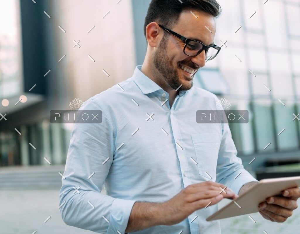 demo-attachment-815-portrait-of-businessman-in-glasses-holding-tablet-AWVHCJU